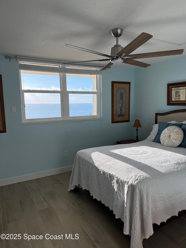 2815 S Atlantic Ave Unit 606, Cocoa Beach, FL 32931 - bedroom featuring wood finished floors, multiple windows, and a ceiling fan