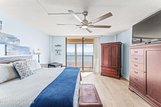 2815 S Atlantic Ave Unit 606, Cocoa Beach, FL 32931 - bedroom featuring access to outside, light wood-type flooring, a textured ceiling, and a ceiling fan