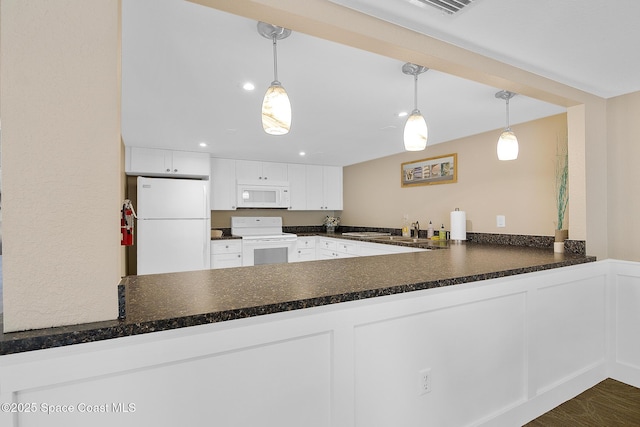 2815 S Atlantic Ave Unit 606, Cocoa Beach, FL 32931 - kitchen featuring white appliances, a peninsula, dark countertops, white cabinetry, and recessed lighting