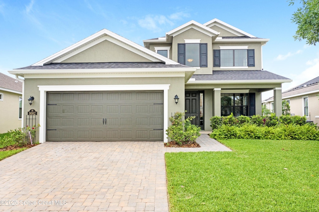 8082 Strom Park Dr, Melbourne, FL 32940 - view of front facade with stucco siding, decorative driveway, a front yard, a garage, and roof with shingles