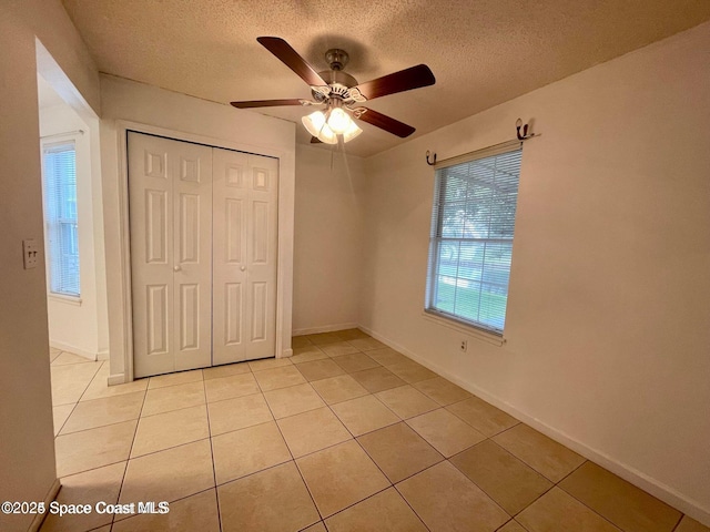 4670 Beck Lake Trl Unit 1-119, Melbourne, FL 32901 - unfurnished bedroom with a textured ceiling, light tile patterned flooring, a closet, and ceiling fan