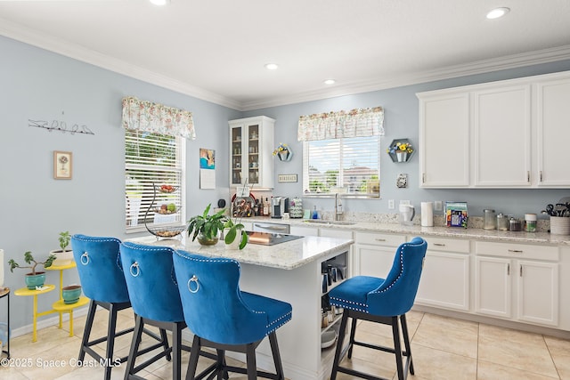 758 Carriage Lake Way, Vero Beach, FL 32968 - kitchen featuring a breakfast bar area, white cabinetry, crown molding, healthy amount of natural light, and recessed lighting