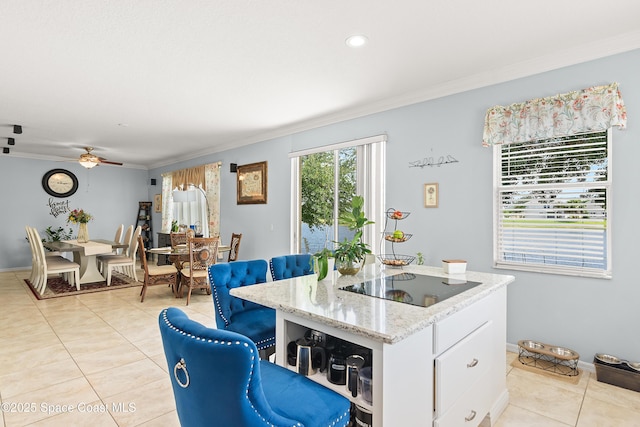 758 Carriage Lake Way, Vero Beach, FL 32968 - kitchen featuring black electric stovetop, light tile patterned flooring, a center island, ornamental molding, and white cabinets