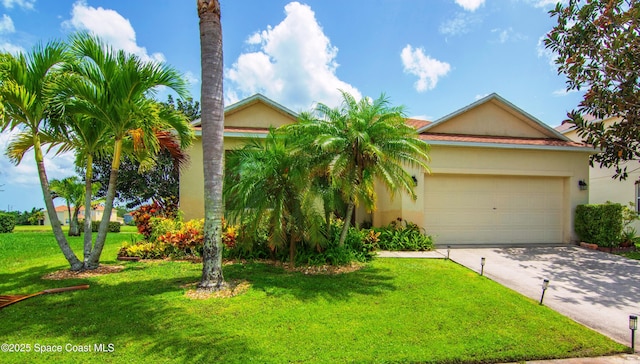 758 Carriage Lake Way, Vero Beach, FL 32968 - view of front of home with stucco siding, concrete driveway, a front lawn, and an attached garage