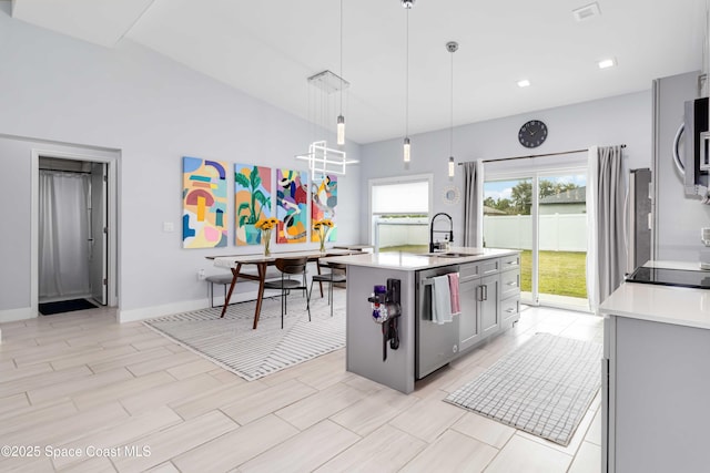 2840 Fontainebleau Ave SE, Palm Bay, FL 32909 - kitchen featuring appliances with stainless steel finishes, light countertops, pendant lighting, and a center island with sink