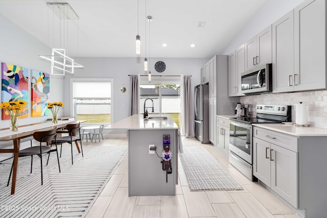 2840 Fontainebleau Ave SE, Palm Bay, FL 32909 - kitchen with appliances with stainless steel finishes, gray cabinets, light countertops, tasteful backsplash, and an island with sink