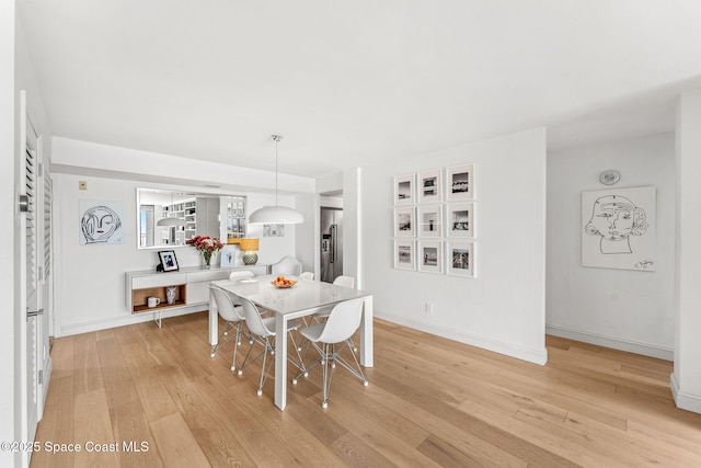 2100 N Atlantic Ave Unit 1110, Cocoa Beach, FL 32931 - dining area featuring light wood-style flooring and baseboards