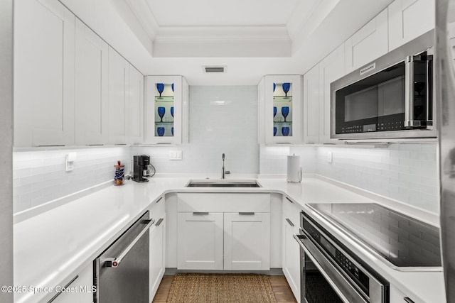 2100 N Atlantic Ave Unit 1110, Cocoa Beach, FL 32931 - kitchen featuring appliances with stainless steel finishes, ornamental molding, decorative backsplash, a raised ceiling, and white cabinets