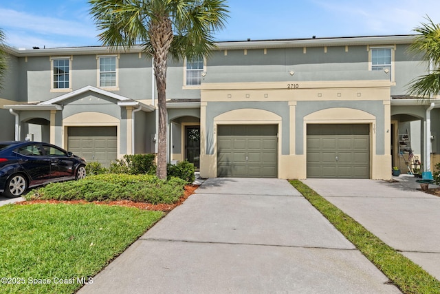 2710 Revolution St Unit 104, Melbourne, FL 32935 - view of property featuring stucco siding and concrete driveway