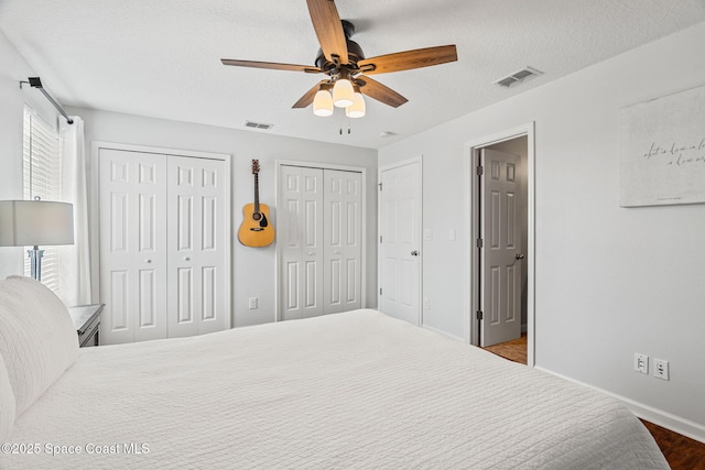 2710 Revolution St Unit 104, Melbourne, FL 32935 - bedroom with two closets, a textured ceiling, ceiling fan, and wood finished floors