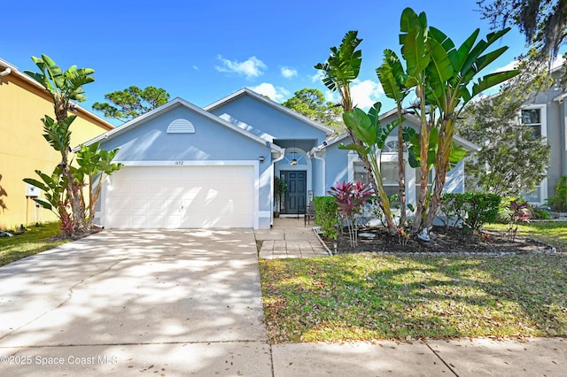 1652 La Maderia Dr, Palm Bay, FL 32908 - view of front of home with stucco siding, a garage, and driveway