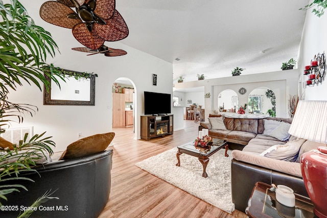 1652 La Maderia Dr, Palm Bay, FL 32908 - living room featuring high vaulted ceiling, arched walkways, a ceiling fan, and light wood-style floors