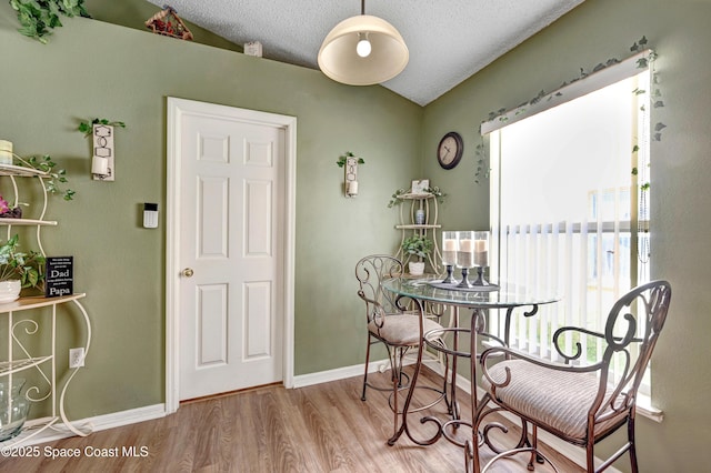 1652 La Maderia Dr, Palm Bay, FL 32908 - dining area featuring lofted ceiling, wood finished floors, and a textured ceiling
