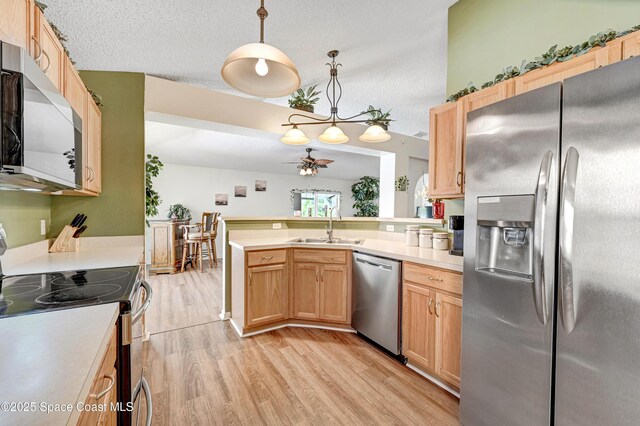 1652 La Maderia Dr, Palm Bay, FL 32908 - kitchen featuring appliances with stainless steel finishes, light wood-style floors, light countertops, a ceiling fan, and a peninsula