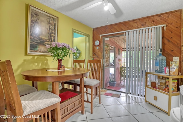905 Spring St NW, Palm Bay, FL 32907 - dining area featuring wooden walls, a ceiling fan, light tile patterned flooring, and a textured ceiling