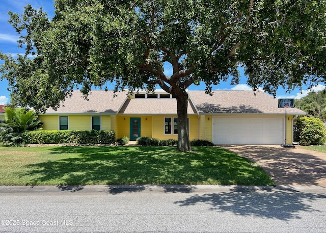 33 Yawl Dr, Cocoa Beach, FL 32931 - view of front of home with driveway, a garage, a front lawn, and roof with shingles