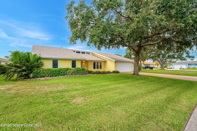 33 Yawl Dr, Cocoa Beach, FL 32931 - view of front of property featuring an attached garage, driveway, and a front lawn