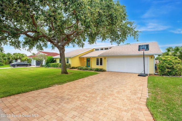 33 Yawl Dr, Cocoa Beach, FL 32931 - view of front of property featuring an attached garage, decorative driveway, a front lawn, and roof with shingles