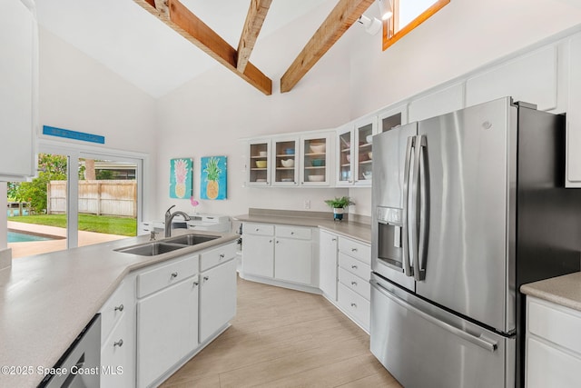 33 Yawl Dr, Cocoa Beach, FL 32931 - kitchen featuring stainless steel fridge, high vaulted ceiling, beamed ceiling, light countertops, and white cabinetry