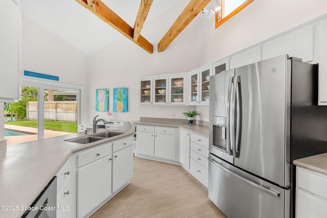 33 Yawl Dr, Cocoa Beach, FL 32931 - kitchen with stainless steel fridge, high vaulted ceiling, beam ceiling, light countertops, and white cabinets