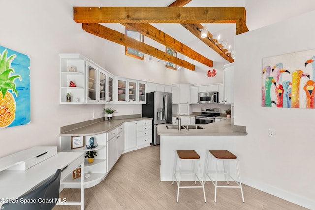 33 Yawl Dr, Cocoa Beach, FL 32931 - kitchen with appliances with stainless steel finishes, open shelves, a peninsula, beamed ceiling, and high vaulted ceiling