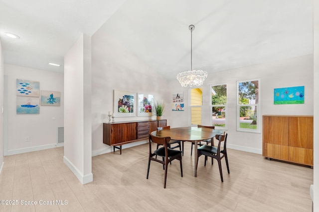 33 Yawl Dr, Cocoa Beach, FL 32931 - dining space featuring light wood finished floors, a chandelier, and vaulted ceiling