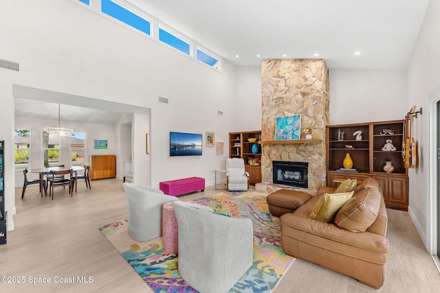 33 Yawl Dr, Cocoa Beach, FL 32931 - living area with light wood-style flooring, a chandelier, a towering ceiling, a fireplace, and recessed lighting