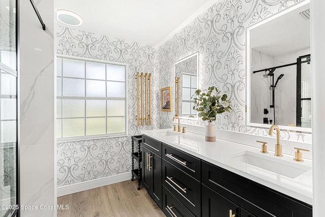 494 Fernandina St NW, Palm Bay, FL 32907 - bathroom featuring wallpapered walls, double vanity, wood finished floors, and a shower with shower door