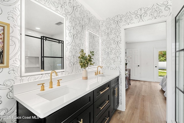 494 Fernandina St NW, Palm Bay, FL 32907 - full bath with wallpapered walls, wood finished floors, double vanity, and a shower with door