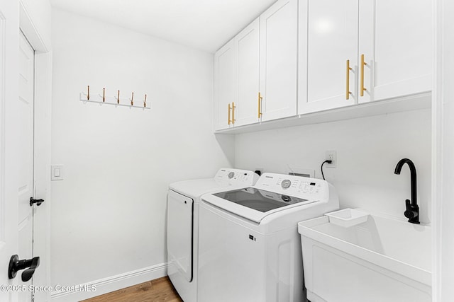 494 Fernandina St NW, Palm Bay, FL 32907 - washroom featuring washing machine and dryer, cabinet space, and light wood-type flooring