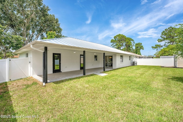494 Fernandina St NW, Palm Bay, FL 32907 - back of house with stucco siding, a gate, a patio, and a metal roof