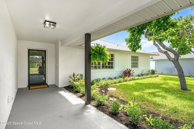 494 Fernandina St NW, Palm Bay, FL 32907 - entrance to property with stucco siding, a lawn, a standing seam roof, and a metal roof