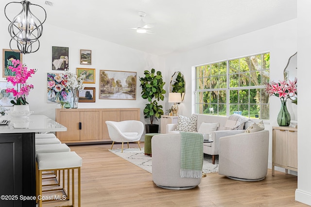 494 Fernandina St NW, Palm Bay, FL 32907 - living room featuring light wood finished floors, vaulted ceiling, a ceiling fan, and a chandelier