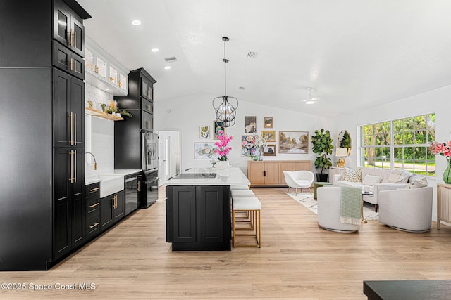 494 Fernandina St NW, Palm Bay, FL 32907 - kitchen with dark cabinetry, light countertops, vaulted ceiling, a ceiling fan, and glass insert cabinets