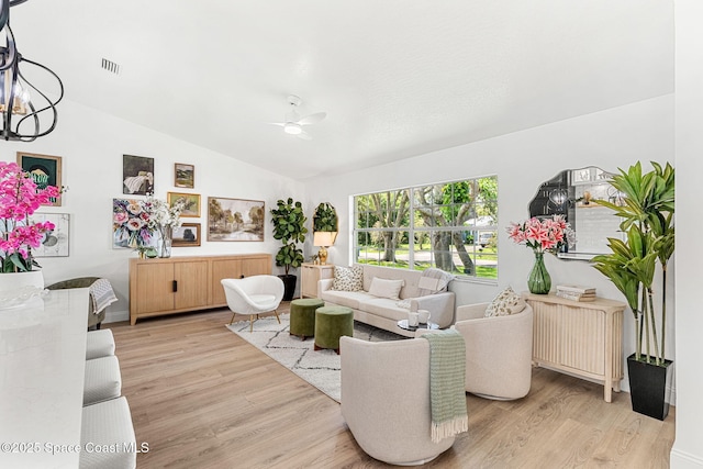 494 Fernandina St NW, Palm Bay, FL 32907 - living room featuring light wood-type flooring, ceiling fan, lofted ceiling, and a chandelier