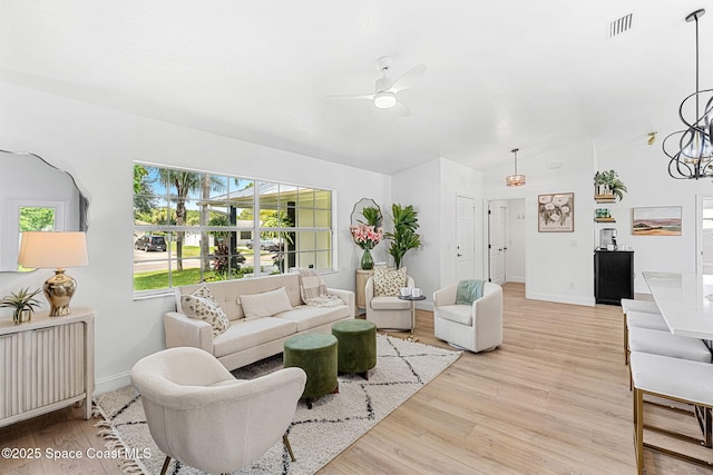 494 Fernandina St NW, Palm Bay, FL 32907 - living area featuring ceiling fan, light wood-style flooring, vaulted ceiling, and a chandelier