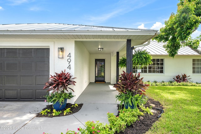 494 Fernandina St NW, Palm Bay, FL 32907 - doorway to property with stucco siding, a garage, a lawn, and a porch