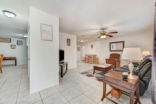 1216 Cannon St, Melbourne, FL 32935 - living area featuring light tile patterned floors, a ceiling fan, and a textured ceiling