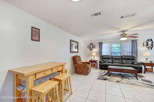 1216 Cannon St, Melbourne, FL 32935 - living room featuring light tile patterned floors, a textured ceiling, and a ceiling fan