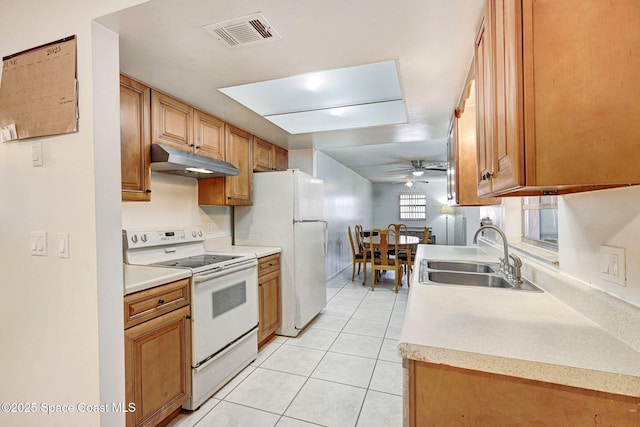 1216 Cannon St, Melbourne, FL 32935 - kitchen with white appliances, under cabinet range hood, a ceiling fan, light tile patterned flooring, and brown cabinetry