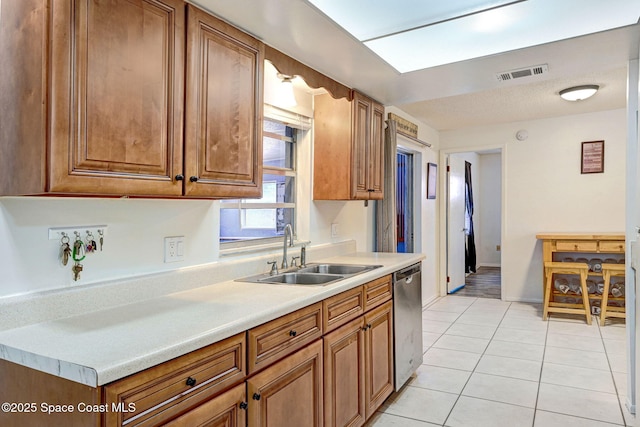 1216 Cannon St, Melbourne, FL 32935 - kitchen featuring dishwasher, light countertops, light tile patterned floors, and brown cabinets
