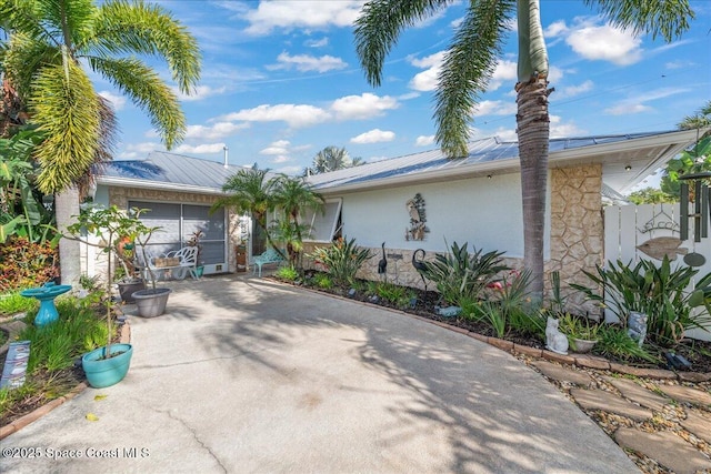 2975 Matthew Dr, Rockledge, FL 32955 - ranch-style house with stucco siding, a metal roof, and stone siding