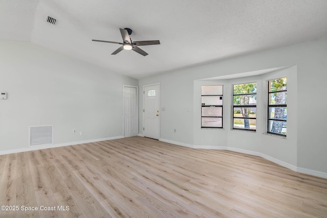 1384 Vancouver Ave SE, Palm Bay, FL 32909 - empty room with a ceiling fan, light wood-type flooring, lofted ceiling, and a textured ceiling