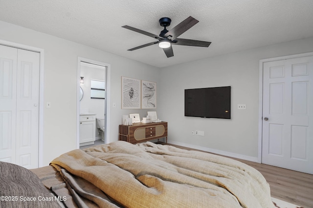 1384 Vancouver Ave SE, Palm Bay, FL 32909 - bedroom with light wood-style floors, ensuite bath, a closet, a textured ceiling, and a ceiling fan