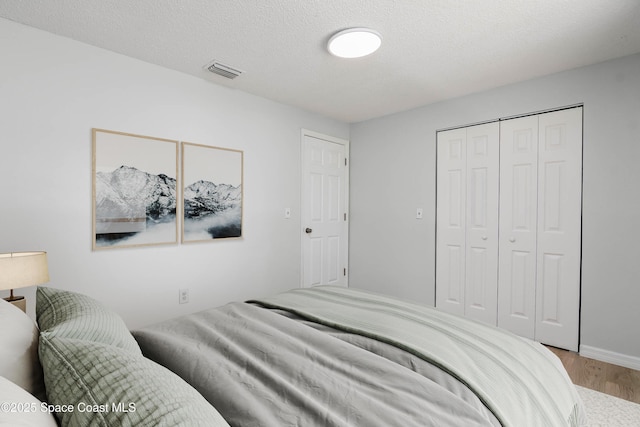 1384 Vancouver Ave SE, Palm Bay, FL 32909 - bedroom with wood finished floors, a closet, and a textured ceiling