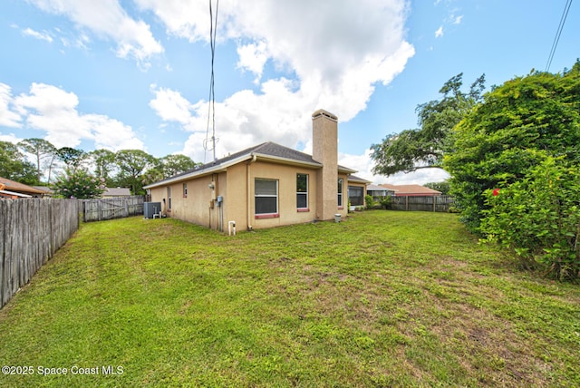 6980 Cairo Rd, Cocoa, FL 32927 - back of property featuring a chimney, a fenced backyard, and stucco siding