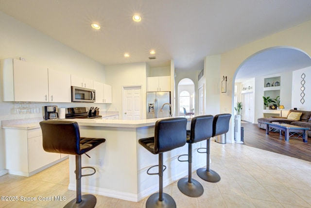6980 Cairo Rd, Cocoa, FL 32927 - kitchen featuring stainless steel appliances, arched walkways, a kitchen breakfast bar, light countertops, and recessed lighting