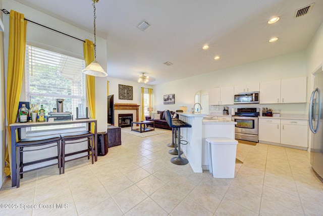 6980 Cairo Rd, Cocoa, FL 32927 - kitchen featuring appliances with stainless steel finishes, healthy amount of natural light, light countertops, recessed lighting, and white cabinets