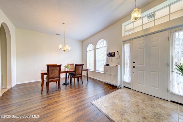 6980 Cairo Rd, Cocoa, FL 32927 - entrance foyer featuring arched walkways, dark wood-type flooring, and a chandelier