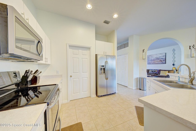 6980 Cairo Rd, Cocoa, FL 32927 - kitchen with appliances with stainless steel finishes, recessed lighting, white cabinets, light tile patterned flooring, and light countertops